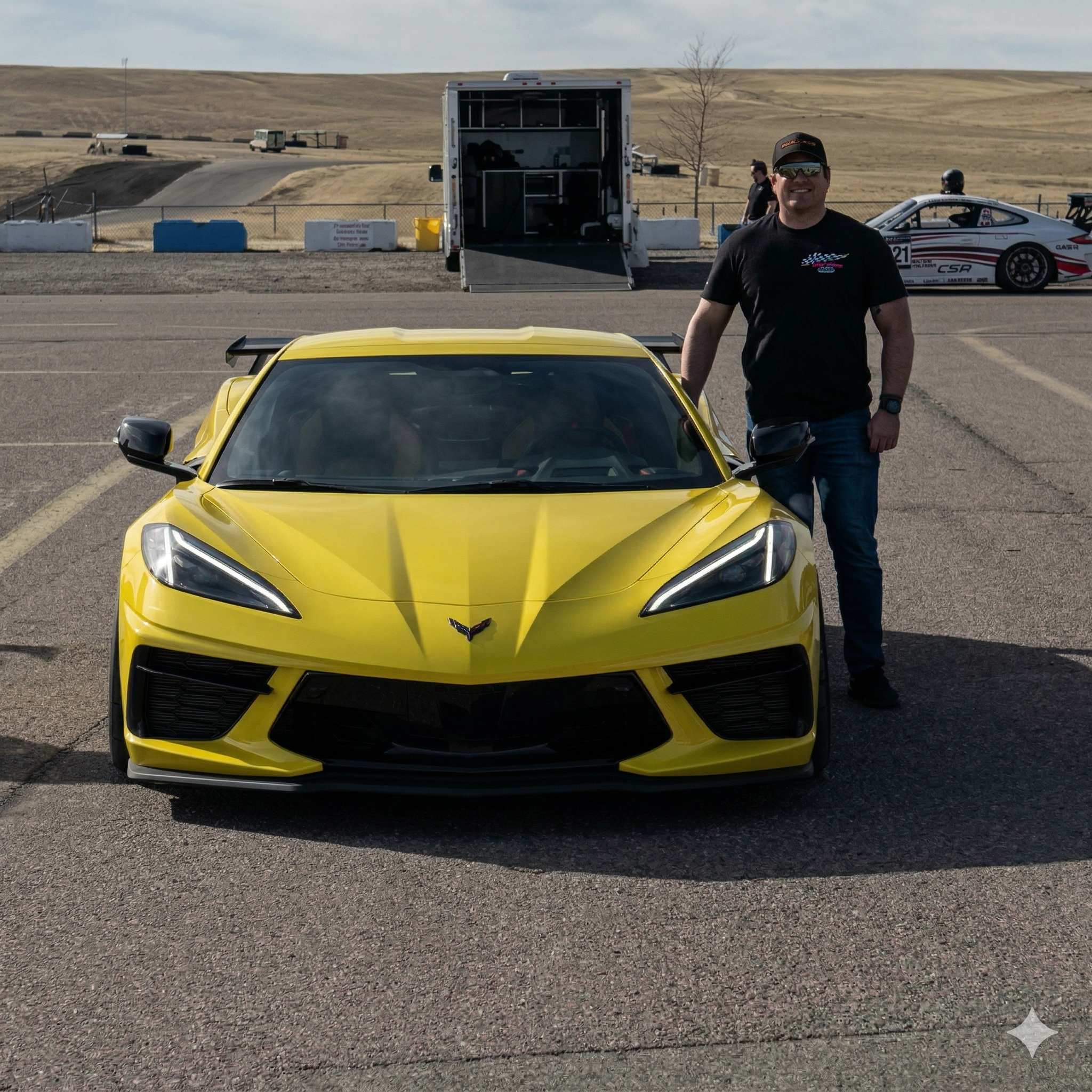 Steve standing in front of yellow Corvette C8 at track event