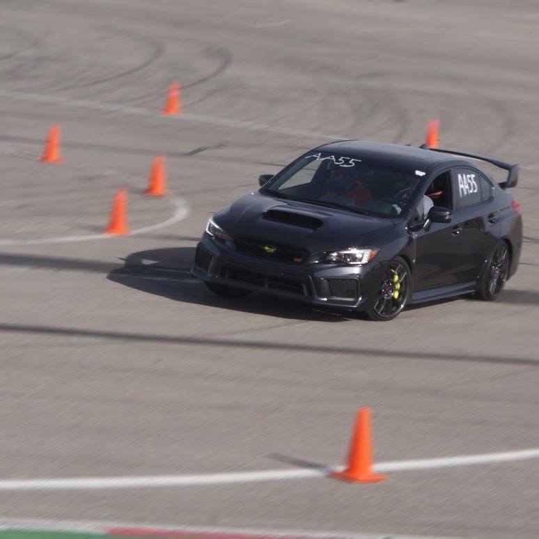 Black Subaru STI autocrossing through cones